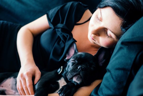 Mujer durmiendo con perro bulldog francés